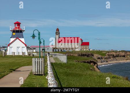 Phare EN BOIS ET COULEURS ARCADIENNE ET L'ÉGLISE CATHOLIQUE DES SAINTS SIMON ET JUDE, GRANDE-ANSE, NOUVEAU BRUNSWICK, CANADA, AMÉRIQUE DU NORD Banque D'Images