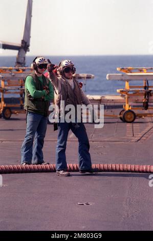 Un membre de l'équipage du pont de vol signale à un pilote pendant les opérations de vol à bord du porte-avions à propulsion nucléaire USS DWIGHT D. EISENHOWER (CVN-69). Pays: Mer méditerranée (MED) Banque D'Images