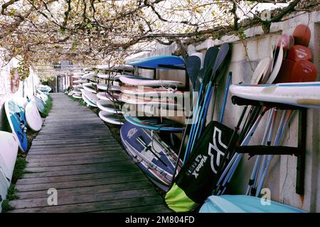 Une passerelle avec des bateaux à aubes et des planches de surf à Batroun, Liban. Banque D'Images