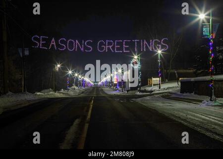 Joyeuses fêtes pour accueillir les voyageurs à St. Croix Falls, Wisconsin USA avec les lumières de la ville des lampadaires en arrière-plan. Banque D'Images