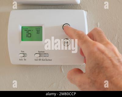 Réglage du thermostat numérique sur froid et programmation de la climatisation à une température d'économie d'énergie de 78 degrés. Banque D'Images