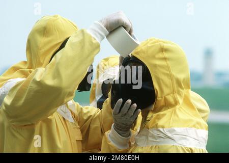 Les membres de la Force d'intervention en cas de catastrophe utilisent du ruban de masquage pour sceller les zones vulnérables de leurs combinaisons de protection nucléaire-biologique-chimique (NBC) lorsqu'ils participent à l'exercice DE BOUCLIER GLOBAL au quartier général du Commandement aérien stratégique (sac). Opération/série du sujet : BOUCLIER MONDIAL base : base aérienne de l'Offutt État : Nebraska (ne) pays : États-Unis d'Amérique (USA) Banque D'Images