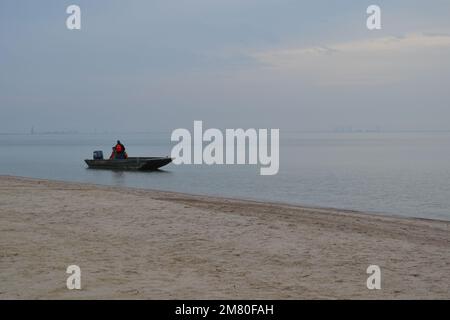 Tranquille Foggy Morning sur la côte de Corpus Christi, Texas - Une scène portuaire paisible avec un bateau solitaire dérivant à travers la brume Banque D'Images