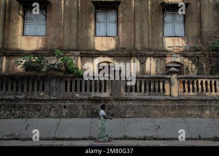 Une femme marche en face d'un vieux bâtiment, Myanmar Banque D'Images