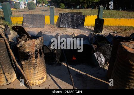 Travailleurs dans la fumée et la chaleur. Les routes sont pavées à la main à Mawlamyine, au Myanmar Banque D'Images