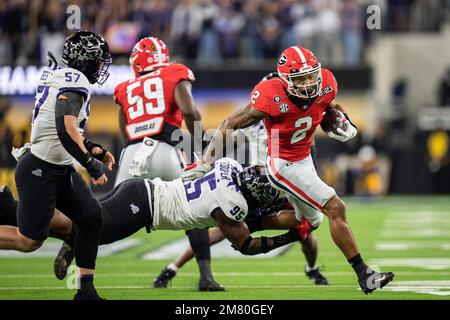 Georgia Bulldogs en arrière Kendall Milton (2) dirige le ballon comme TCU Horned Frogs le joueur de ligne défensive Terrell Cooper (95) défend pendant le College FO Banque D'Images