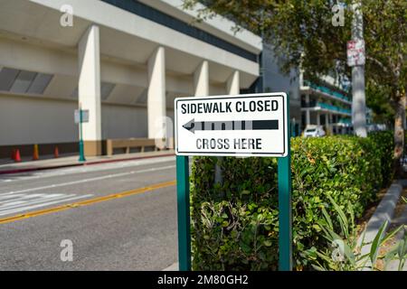 Anaheim, CA, Etats-Unis – 1 novembre 2022 : trottoir fermé. Passez ici le panneau avec la flèche affiché dans le quartier du Centre des congrès d'Anaheim, Californie. Banque D'Images
