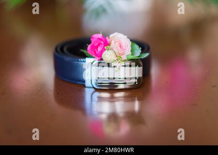 Petit bouquet de fleurs près des vêtements de mariage d'homme. Banque D'Images