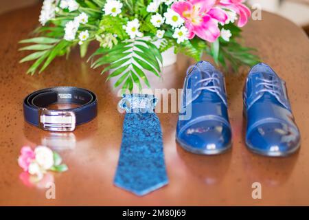 Petit bouquet de fleurs près des vêtements de mariage d'homme. Banque D'Images