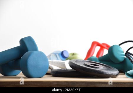 Arrière-plan de l'équipement sportif et la vie saine à la maison sur un plancher en bois avec haltères, poids, élastiques pour la vie saine avec blanc isolé b Banque D'Images