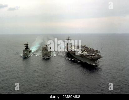 Une vue aérienne à tribord de l'arc du porte-avions à propulsion nucléaire USS DWIGHT D. EISENHOWER (CVN-69), à droite, au cours du réapprovisionnement en cours avec le centre USS Oiler SAVANNAH (AOR-4) de la classe Wichita. Le destroyer USS SPRUANCE (DD-963) est réapprovisionné du côté tribord du graisseur. Pays : inconnu Banque D'Images