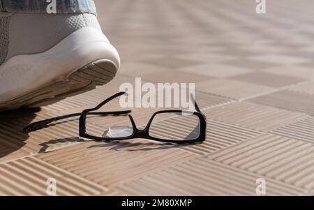 pied sur les lunettes. accident le verres cassés sur les carreaux de rue Banque D'Images