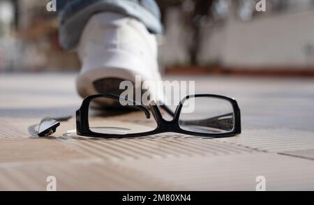 pied sur les lunettes. accident le verres cassés sur les carreaux de rue Banque D'Images