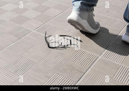 pied sur les lunettes. accident le verres cassés sur les carreaux de rue Banque D'Images