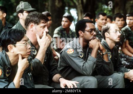 Le personnel de la Force aérienne des États-Unis écoute une conférence sur l'identification des plantes comestibles donnée par les membres des forces spéciales de l'Armée royale thaïlandaise lors de l'entraînement multidisciplinaire de survie dans la jungle. Base: Koke Kathiem Air base pays: Thaïlande (THA) Banque D'Images