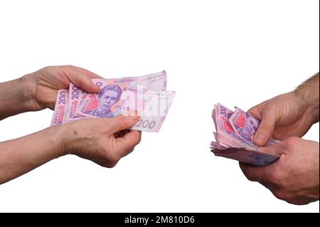 Un retraité prend de l'argent des mains d'un jeune homme. Le concept de l'aide financière. Une femme âgée et une hryvnia ukrainienne. Transfert d'argent. Banque D'Images