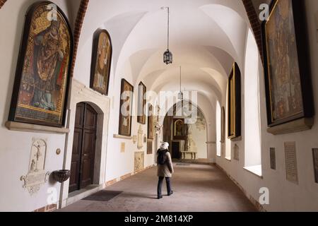 Un visiteur marchant dans les cloîtres de l'intérieur de l'église baroque médiévale de Sainte-Anne datant du 14th siècle ; vieille ville de Cracovie, Pologne de Cracovie Banque D'Images
