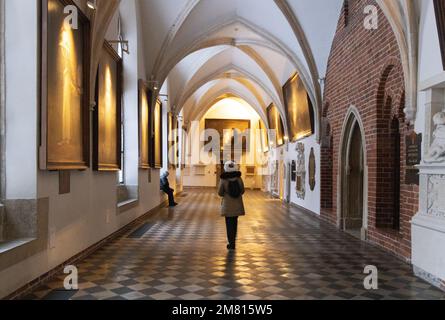 Église médiévale ; visiteurs dans le cloître de l'intérieur de l'église dominicaine de Cracovie datant du 13th siècle, alias. Basilique Sainte-Trinité de Cracovie, Pologne. Banque D'Images