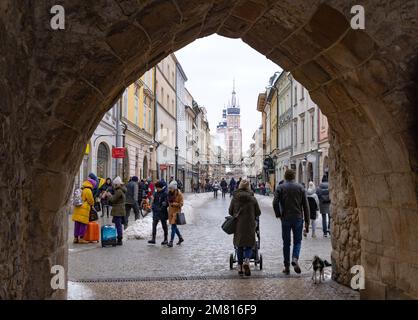 Vieille ville de Cracovie ; personnes marchant à travers la porte de l'arche dans le mur médiéval, en bas de la rue Florianska vers la place principale, Cracovie Pologne Europe Banque D'Images