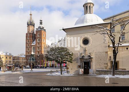 La place du marché principal de Cracovie en hiver, l'église Saint-Marys à l'arrière et l'église romane Saint-Marc datant du 11th siècle Wojciech à l'avant. Vieille ville de Cracovie. Banque D'Images