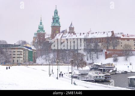 Neige d'hiver de Cracovie ; château de Wawel et cathédrale de Wawel dans la vieille ville de Cracovie, avec des bateaux sur la Vistule dans un paysage hivernal, Cracovie Pologne Banque D'Images