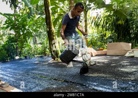 Le travail traditionnel sri-lankais verse du goudron sur les routes sur 2022.12.12 à Galle, Sri Lanka . Photo de haute qualité Banque D'Images