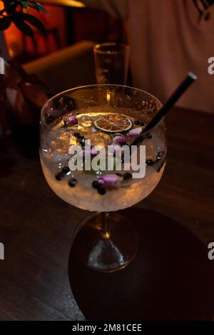 tout en gin tonique avec la rose sèche jupiter baies poivre et glaçons dans un club Banque D'Images