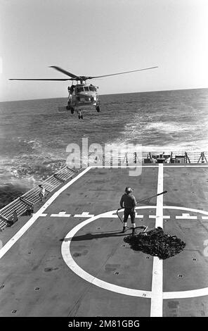 Le premier hélicoptère 60B Seahawk de la Marine, Mark III LAMPS (Light Airborne Multi-Purpose System), s'approche du pont de vol de la frégate de missile guidé USS CROMMELIN (FFG 37), pour ramasser un filet de cargaison. L'hélicoptère subit le pont de vol l. pays : Océan Pacifique (POC) Banque D'Images