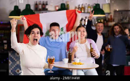 Les fans péruviens enthousiastes crient avec joie au bar à bière. Victoire péruvienne Banque D'Images