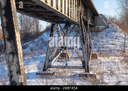 Poutres d'acier sous un pont ferroviaire, dans un après-midi ensoleillé d'hiver dans le Nord de l'Ontario. Banque D'Images