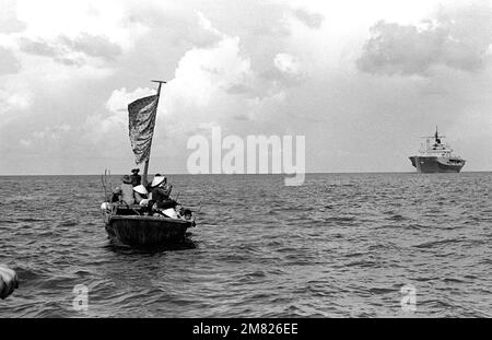 Un bateau de pêche de 35 pieds s'approche du navire de commandement amphibie USS BLUE RIDGE (LCC 19). La BLUE RIDGE a secouru 35 refuges à 350 milles au nord-est de Cam Ranh Bay, au Vietnam, après avoir passé huit jours en mer dans le bateau. Pays: Mer de Chine méridionale Banque D'Images