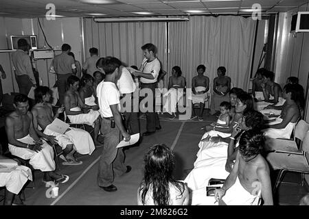 Les réfugiés vietnamiens sont examinés et traités à bord de l'USS BLUE RIDGE (LCC 19). Les 35 refuges ont été sauvés par le navire de commandement amphibie à 350 milles au nord-est de Cam Ranh Bay, au Vietnam, après huit jours en mer dans un bateau de pêche de 35 pieds. Base: USS Blue Ridge (LCC 19) pays: Mer de Chine méridionale Banque D'Images