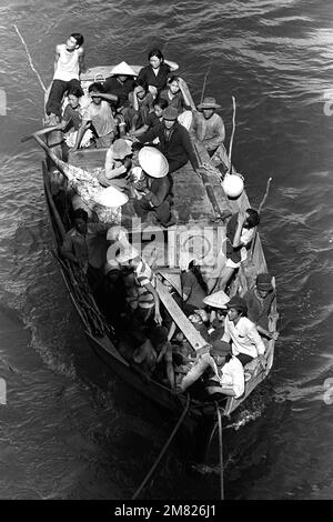 Un bateau transportant 35 réfugiés vietnamiens vient le long du navire de commandement amphibie USS BLUE RIDGE (LCC-19). Les réfugiés ont été sauvés à 350 miles au nord-est de Cam Ranh Bay, au Vietnam, après avoir passé huit jours en mer dans un bateau de pêche de 35 pieds. Pays: Mer de Chine méridionale Banque D'Images