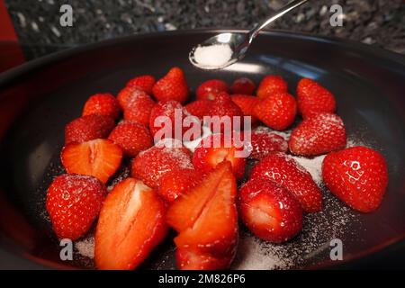 Cuisine souabe, préparation de kratzete sucré aux fraises flambées, fruits dans une casserole saupoudrés de sucre, cuillère à café, végétarien, dessert Banque D'Images