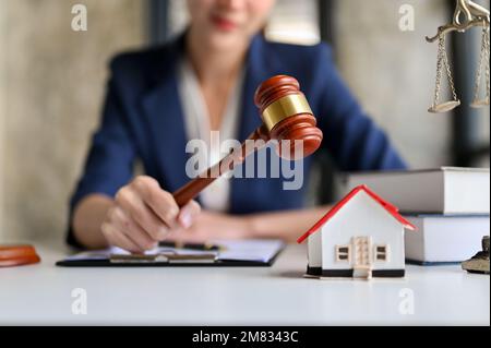 Image sélective, Une femme avocate asiatique professionnelle millénaires, PR avocat tenant un juge gavel ou juge marteau à son bureau. Banque D'Images