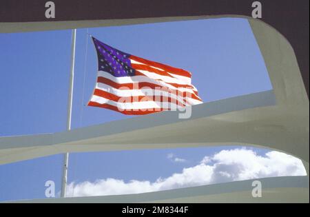 Un drapeau vole en Berne au sommet du Mémorial de l'USS ARIZONA (BB-39) pour commémorer le 43rd anniversaire de l'attaque japonaise. Base: Pearl Harbor État: Hawaï (HI) pays: Etats-Unis d'Amérique (USA) Banque D'Images