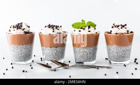 Une rangée de desserts au chocolat au chia avec des cuillères à l'avant, prêts à manger. Banque D'Images