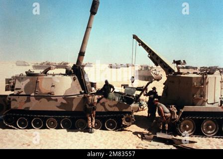 Les mécaniciens travaillent dans le compartiment moteur d'un obusier automoteur M-109A1 155mm, à gauche, lors de l'exercice conjoint États-Unis/Égypte Bright Star '85. Le véhicule de récupération blindé léger M-578 à droite a été utilisé pour déposer le moteur de l'obusier. Sujet opération/série: BRIGHT STAR '85 pays: Egypte (EGY) Banque D'Images