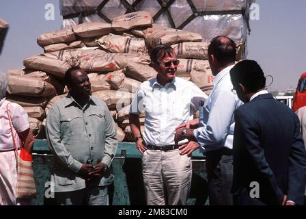 Le vice-président George Bush, qui était au Soudan lors d'une visite d'information, reçoit un exposé sur l'opération de secours en Éthiopie du Dr Philip Johnston, directeur exécutif DE CARE. Plus de 50 000 livres de nourriture et de fournitures ont été livrés à l'aéroport à bord d'un aéronef du 6th Escadron de transport aérien militaire. Base: Khartoum pays: Soudan (SDN) Banque D'Images