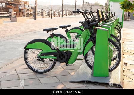 les vélos électriques à louer sont verts dans le parking du centre-ville dans la rue. Mode de transport écologique Banque D'Images