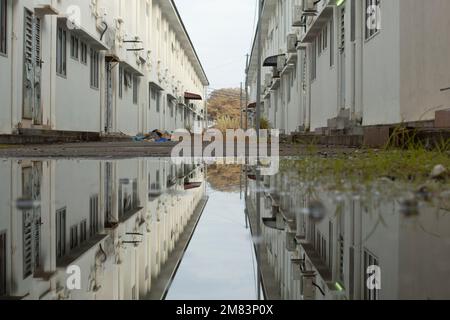 piscine d'eau stagnante après la pluie dans la rue asphaltée de la banlieue Banque D'Images