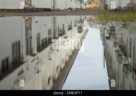 piscine d'eau stagnante après la pluie dans la rue asphaltée de la banlieue Banque D'Images