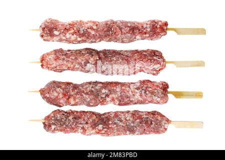 Kebab cru de viande de bœuf ou d'agneau sur brochettes isolées sur fond blanc. Avec masque. Profondeur de champ complète. Superposition de mise au point Banque D'Images