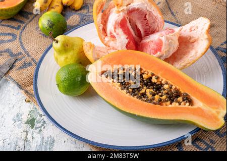 Assiette avec pamplemousse papaye frais et limes Banque D'Images