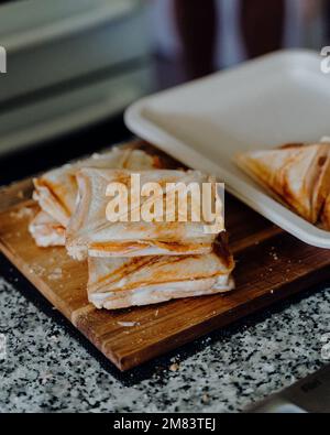 Un gros plan de croque-monsieur Triangle chaud grillé sur un panneau de bois Banque D'Images