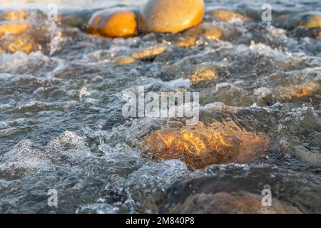 Rivière de montagne qui coule rapidement avec des éclaboussures sur des pierres de rivière Banque D'Images