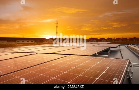 Des panneaux solaires sur les toits de grands bâtiments reflètent le coucher de soleil dans la ville. Énergies renouvelables durables. Concepts énergétiques modernes pour le logement et t Banque D'Images