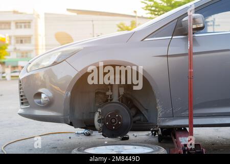 Entretien rapide Remplacement des roues de la voiture avec un cric hydraulique Banque D'Images