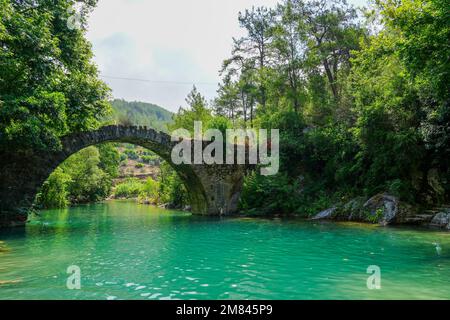 Ancien pont romain sur la rivière Dim en Turquie. Eau turquoise claire et nature verte. Banque D'Images