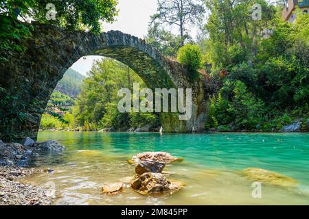 Ancien pont romain sur la rivière Dim en Turquie. Eau turquoise claire et nature verte. Banque D'Images